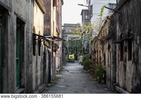 Kolkata, India - February 1, 2020: A Yellow And Green Cng Tuk Tuk Is Parked In An Alley In Between R