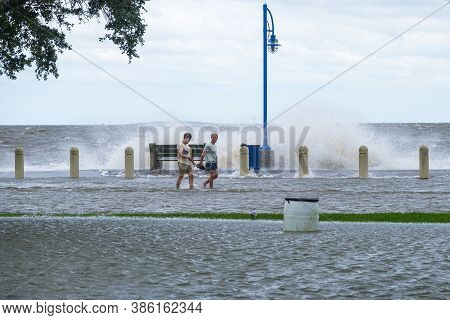 New Orleans, Louisiana/usa - 9/15/2020: Two Men Walking Along Flooded Lakeshore Drive And Lake Pontc