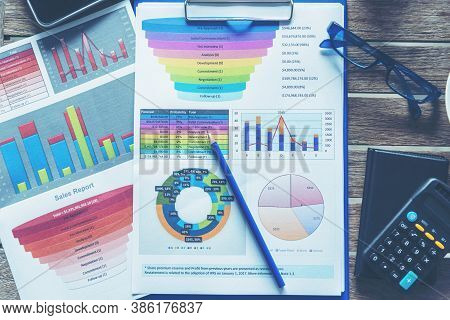 Office Laptop Business Financial Document Chart And Graph On Wooden Table With Coffee Cup. Flat Lay 