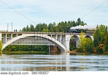Kouvola, Finland - 18 September 2020: Autumn Landscape Of Bridge With Moving Old Steam Passenger Tra
