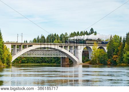 Kouvola, Finland - 18 September 2020: Autumn Landscape Of Bridge With Moving Old Steam Passenger Tra