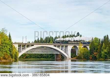 Kouvola, Finland - 18 September 2020: Autumn Landscape Of Bridge With Moving Old Steam Passenger Tra