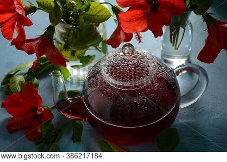 Hibiscus Tea In A Glass Transparent Teapot, And Blossom Flower