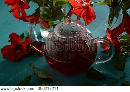 Hibiscus Tea In A Glass Transparent Teapot, And Blossom Flower