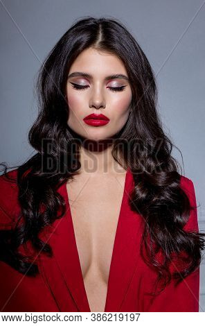 Frontal Portrait Of A Beautiful Sensual Brunette Young Woman With Makeup In Red Suit, With Closed Ey