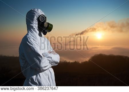 Side View Of Male Environmentalist With Crossed Arms Looking Aside While Thermal Chimneys Producing 