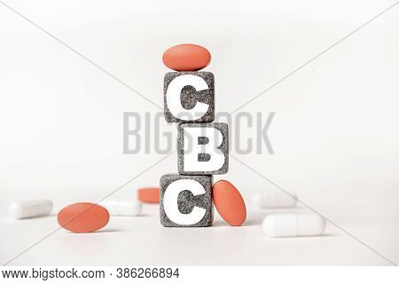 A Group Of White And Red Pills And Cubes With The Word Cbc Complete Blood Count. On Them, White Back