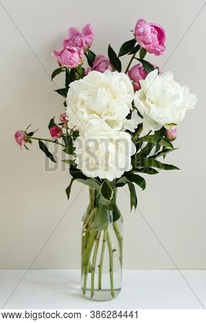 Simple Sloopy Flower Bouquet Of Pink And White Peonies Flowers In A Transparent Vase Over Pastel Bac