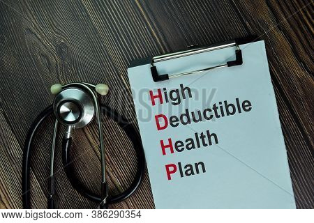 High Deductible Health Plan Write On A Paperwork Isolated On Wooden Table.