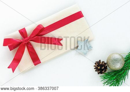 A Craft Paper Envelope Tied With A Red Festive Ribbon Is Intended For A Christmas Present. Christmas