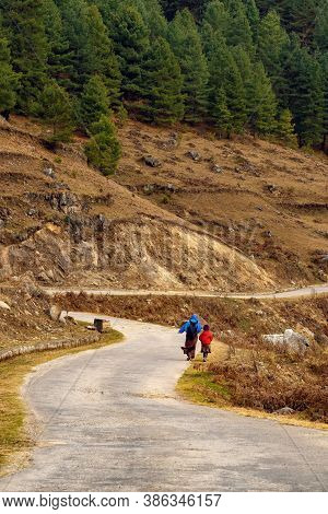 Mother & Son Returning To Home Walking A Long Distance At A Remote Place In Phobjika,bhutan.