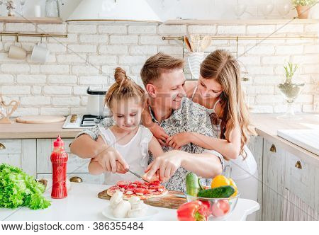 dad with daughters preparing pizza