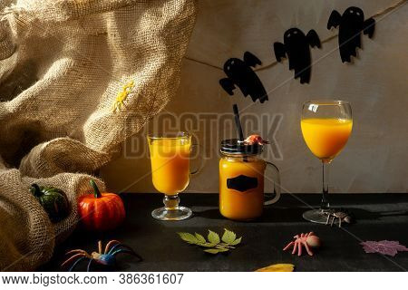 Orange Halloween Mococktails And Holiday Decor On A Dark Mystical Autumn Background. Chosts On Backg