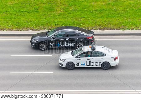 White And Black Passenger Car Uber Taxi Rides On The Highway Aerial View. Russia, Saint-petersburg. 