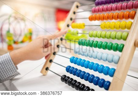 Male Hand Calculating With Beads On Wooden Rainbow Abacus For Number Calculation. Mathematics Learni