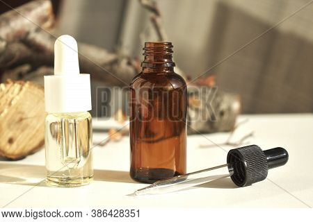 Cosmetic Fragrance Oils In Bottles With Pipette On The Background Of Natural Wood And Pastel Colors.