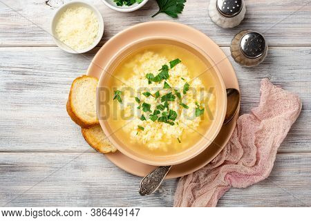 Italian Stracciatella Egg Drop Soup With Parmesan Cheese And Parsley In Bowl On Rustic Wooden Backgr