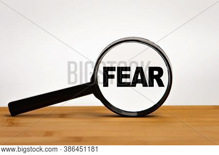 Focused On Business Concept. Magnifier Glass With Word Fear First Encounter Assault Recon On Wooden 