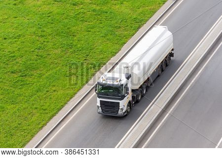 Fuel Truck Driving On The Road Next To The Grass