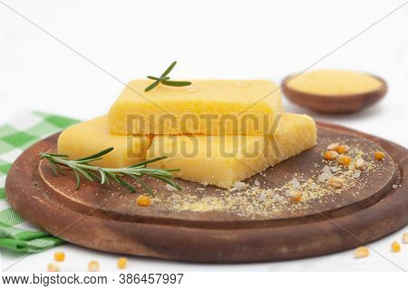 Corn Polenta Slices With Grinded Corn On Wooden Board. Homemade Palenta, Healthy Vegetarian Food.