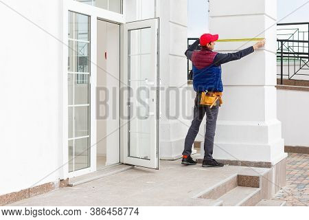 A Worker Installs Panels Beige Siding On The Facade Of The House