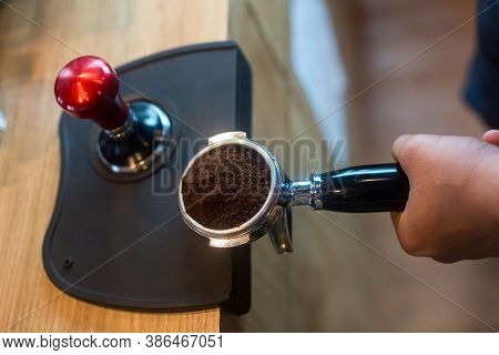 Barista Pressing Coffee In The Machine Holder. Coffee Powder On Coffee Tamper. Barista Using Tamper 
