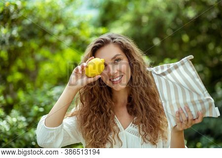 Long -haired Wowan In White Shirt Holding A Lemon And Smiling