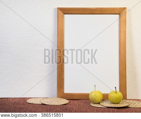 Portrait empty wooden frame mockup with yellow apples. White background. Scandinavian interior, home