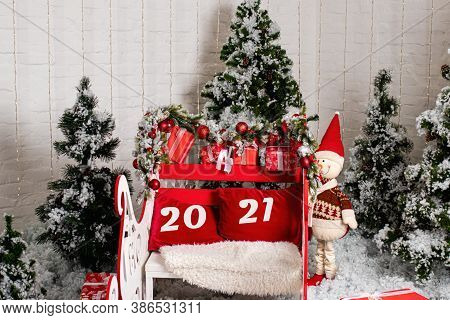 Santa Clauss Sleigh Is Red With The Inscription 2021. Snowman And Snow-planted Christmas Trees. Post