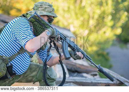 The Airsoft Player Holds The Defense, Takes Aim At The Enemy