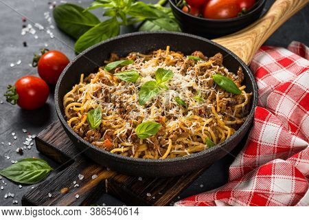 Pasta Bolognese, Spaghetti With Meat Ragout In Tomato Sauce In The Skillet At Black Table. Italian C