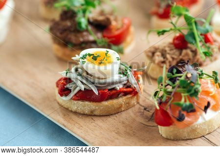 Closeup On Assorted Tappas With Different Toppings On The Wooden Board