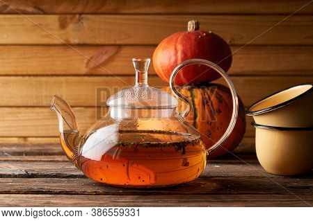 Teapot With Brewed Hot Tea , Pumpkin Fnd Cookies On A Wooden, Cozy Background