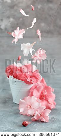White Bucket Full Of Pink Flowers On A Grey Table Close Up