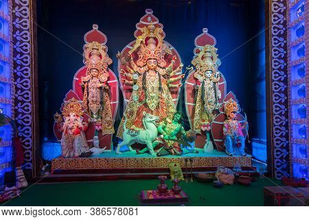 Goddess Durga Idol With Her Family, Durga Puja Festival At Night. Shot Under Colored Light At Howrah