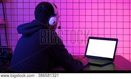 Professional Gamer Playing Video Game On His Laptop. White Displ