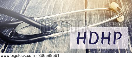 Stethoscope And Inscription Hdhp. High-deductible Health Plan Concept. Lower Premiums And Higher Ded