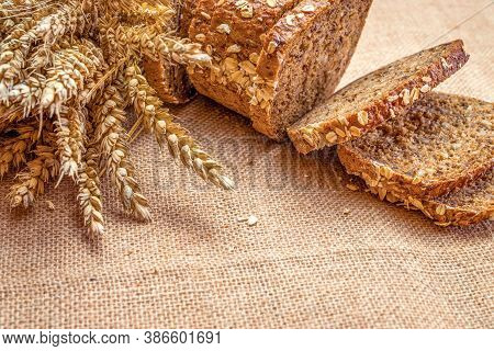 Freshly Baked Bread. Fresh Loaf Of Rustic Traditional Bread With Wheat Grain Ear Or Spike Plant On L
