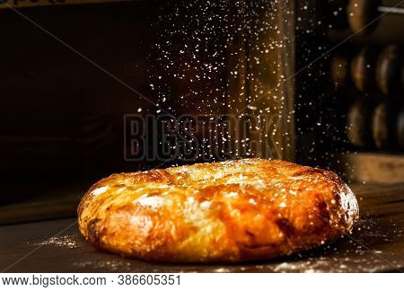 Naan With Cheese Baked In The Oven Lies On A Wooden Table. Flour Falls On Top Of The Cheese Bread. P