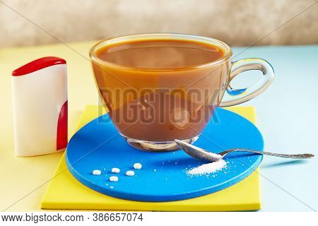 A Cup Of Coffee And Pills Of Sugar Substitute And Natural Sweetener In Powder On A Yellow And Blue P