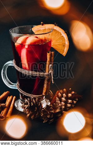 Mulled Wine Hot Christmas Drink With On A Dark Background. Orange Slices, Cinnamon Sticks, Christmas
