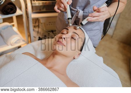 Lateral View Of Woman Facial Massage Spa Procedure. Electric Stimulation Facial Skin Care. Microcurr
