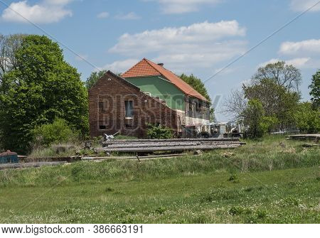 Partily Ruined Brick And Stone Farm House With Wooden Logs At Lusatian Mountains, Early Spring Lands