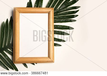 Tropical Stationery Mock-up Scene. Wooden Frame And Green Palm Leaf Isolated On White Background. Tr