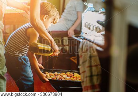 Cute Little Preschooler Boy In Striped T-shirt Help His Mother At Kitchen. Cook At Home. Young Woman
