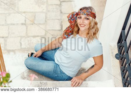 Young Women With T-shirt And Scarf Headband On The Stairs
