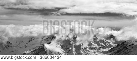 Black And White Snowy Mountains In Sunlight Clouds At Nice Winter Evening. Caucasus Mountains. Svane