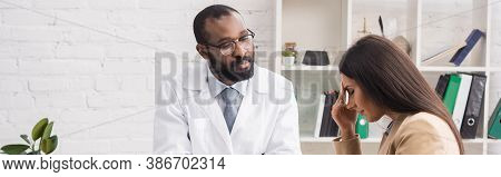 Panoramic Crop Of Serious African American Doctor In Eyeglasses Looking At Diseased Woman Touching F