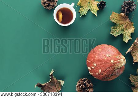 Autumn Composition. Frame Made Of Pumpkins, Dried Leaves, Pine Cones And Tes Cup Background. Templat