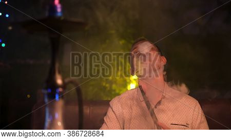 Caucasian Man Exhaling A Fog Cloud And Chilling. Media. Front View Of Handsome Young Guy Smoking Hoo